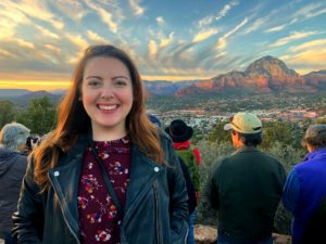 Smiling Hannah in front of a mountain sunset