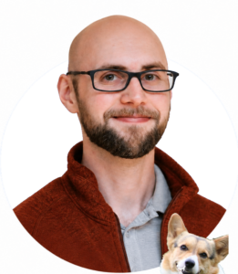 Dave smiling in glasses, with a tiny corgi dog the bottom of the image (Dave loves corgis)