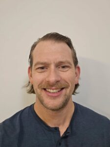 John smiling on a plain background