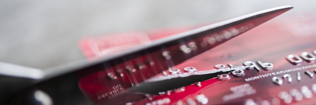 Credit card being cut with scissors, close up with copy space